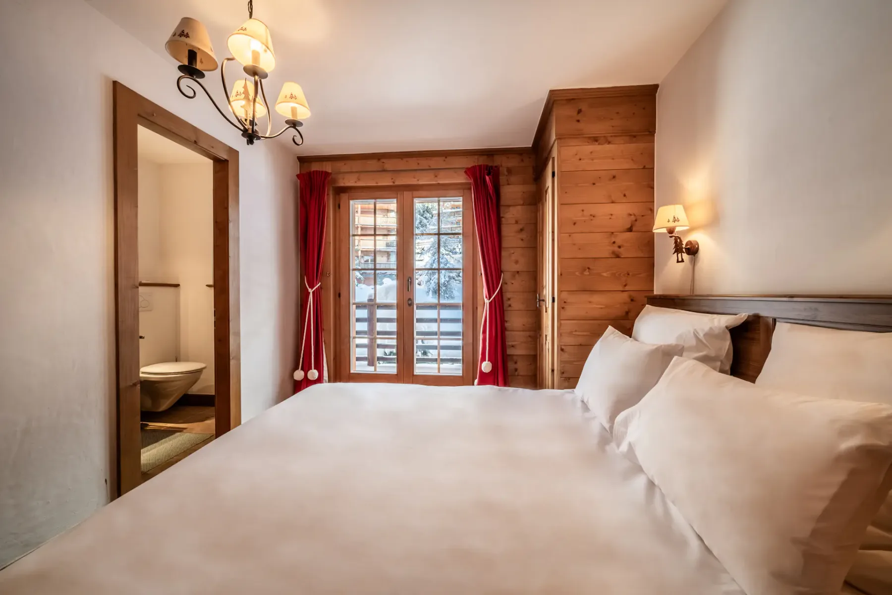A wooden bedroom with a bed and a balcony.