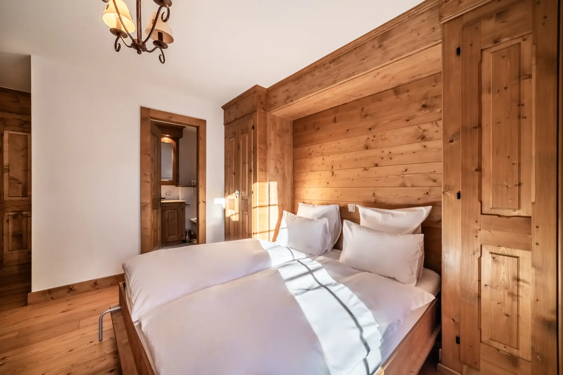 A room with bunk beds and wooden walls.