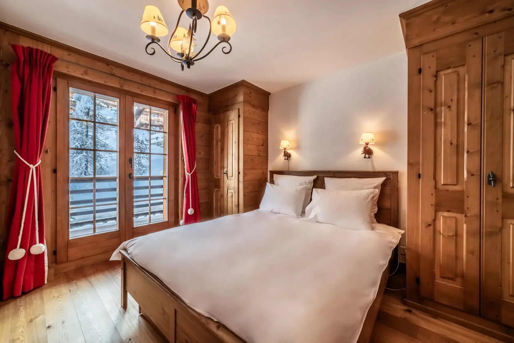 A wooden bedroom with a bed and a balcony.
