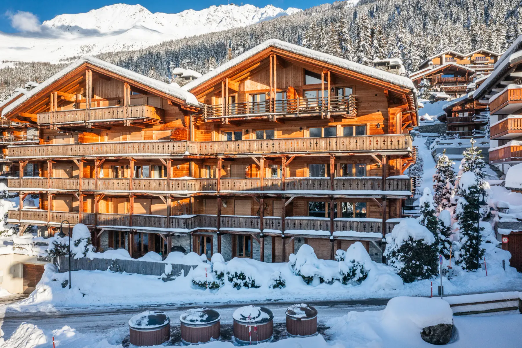A wooden building covered in snow on a snowy mountainside.