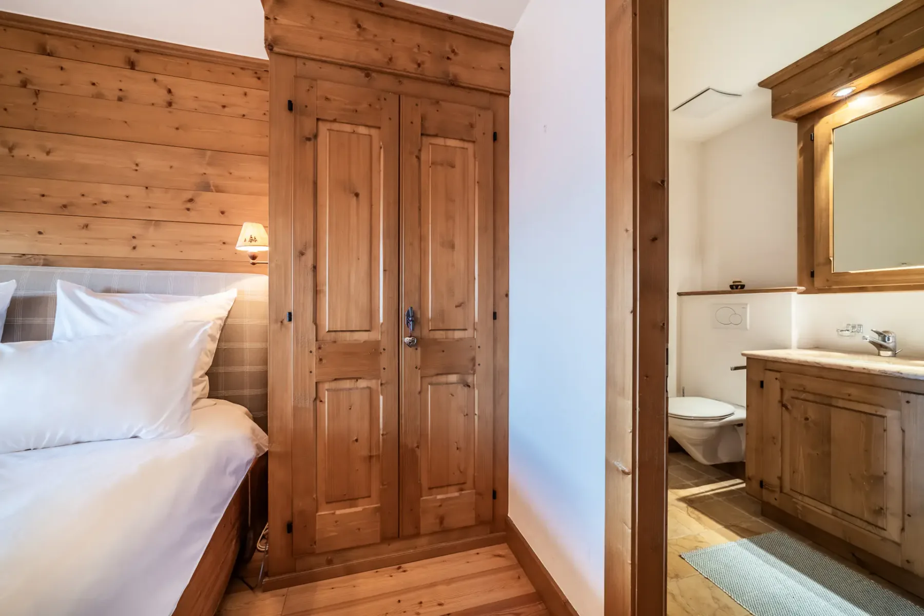 A wooden bedroom with a bed and a balcony.