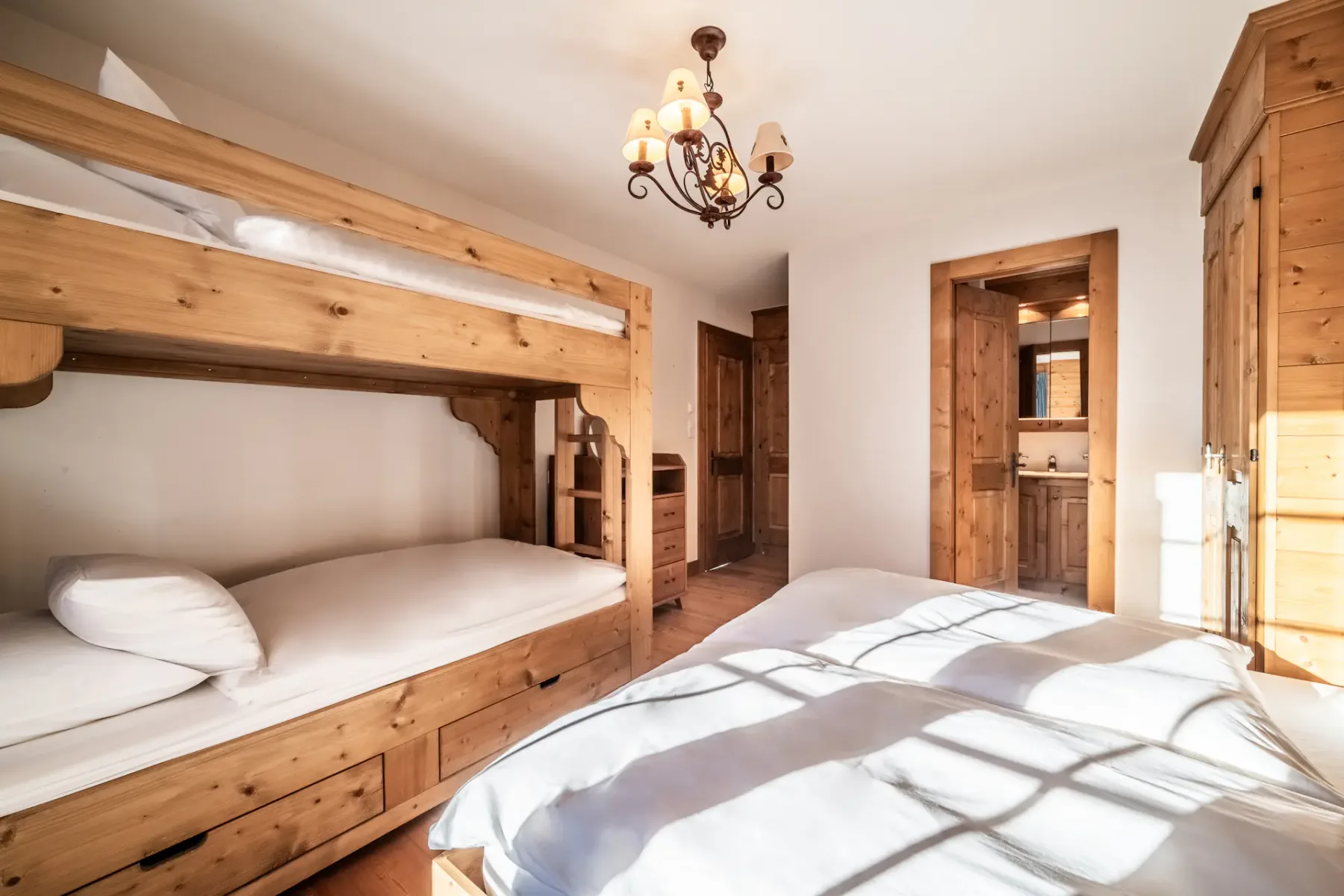 A room with bunk beds and wooden walls.