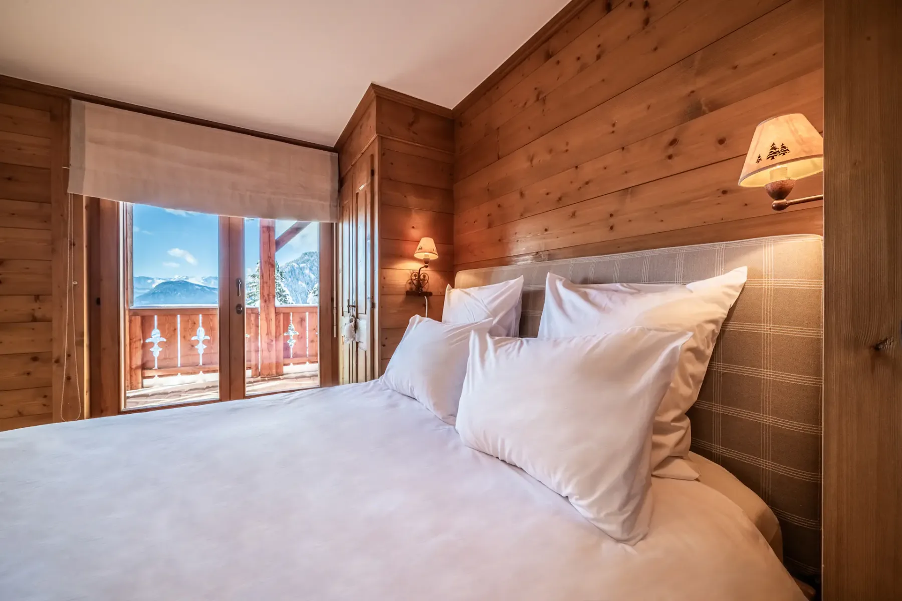 A wooden bedroom with a bed and a balcony.