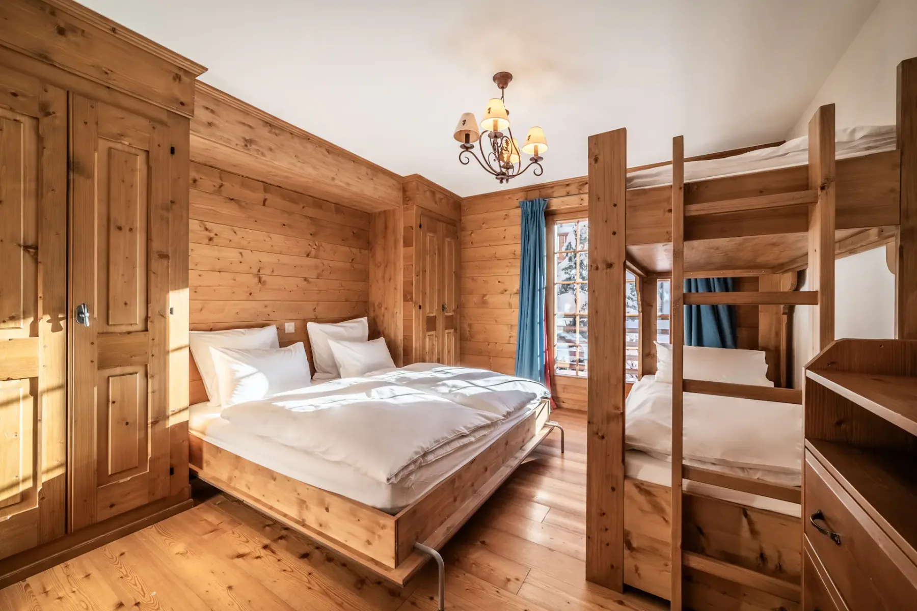 A room with bunk beds and wooden walls.