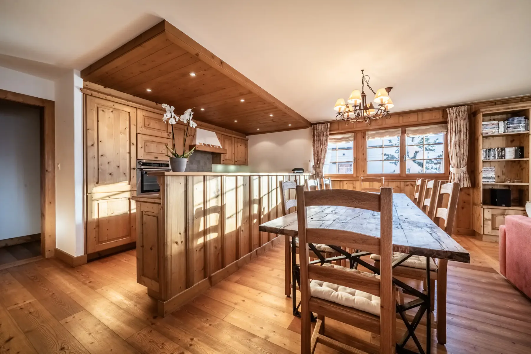Una cocina con suelo de madera y una mesa de comedor.