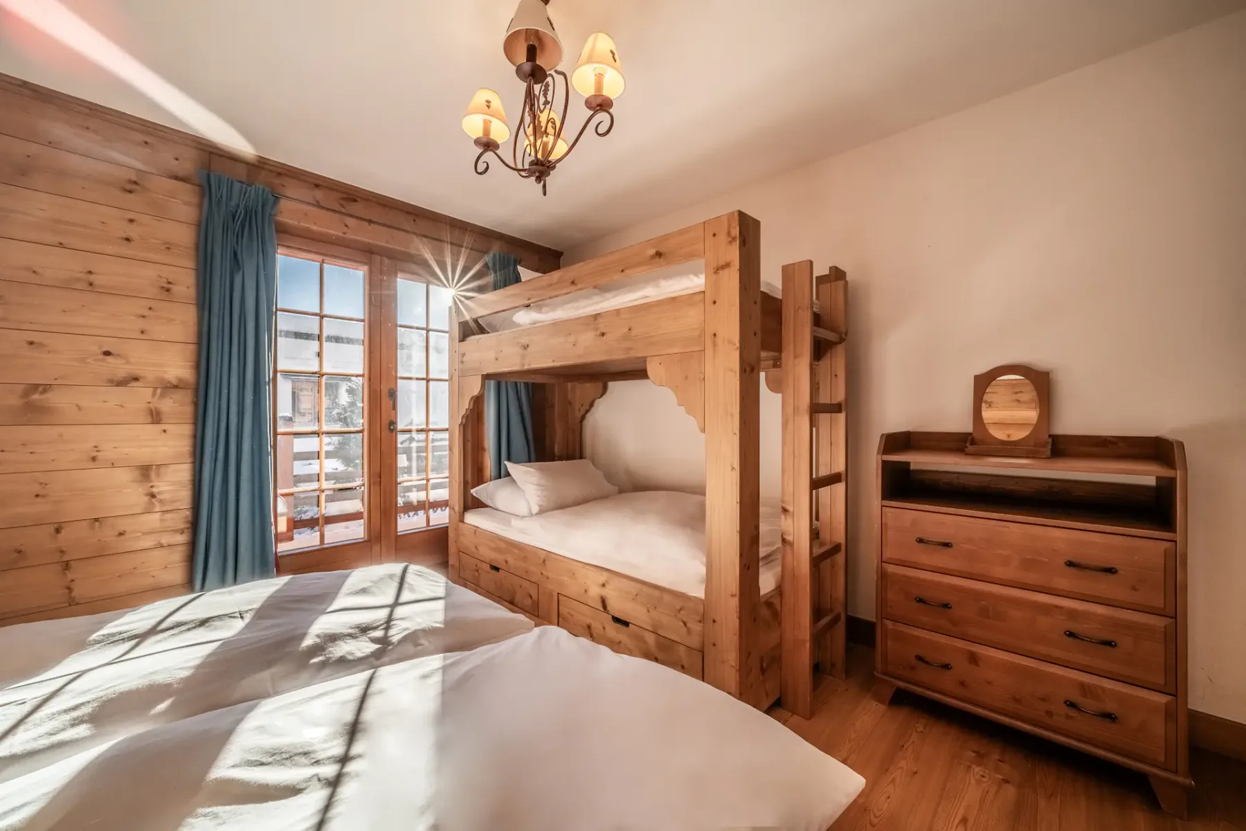 A room with bunk beds and wooden walls.