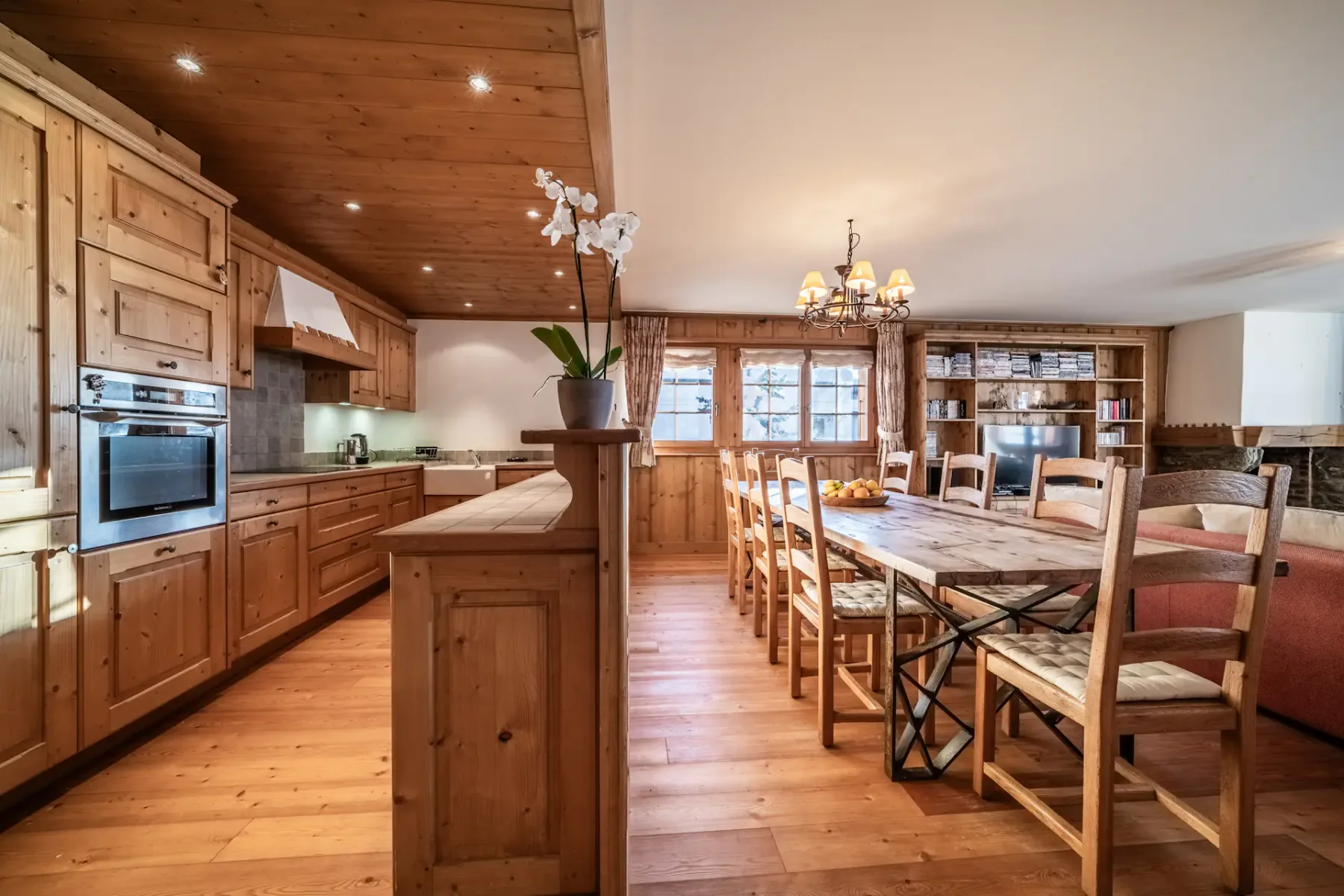 A kitchen with wooden floors and a dining table.