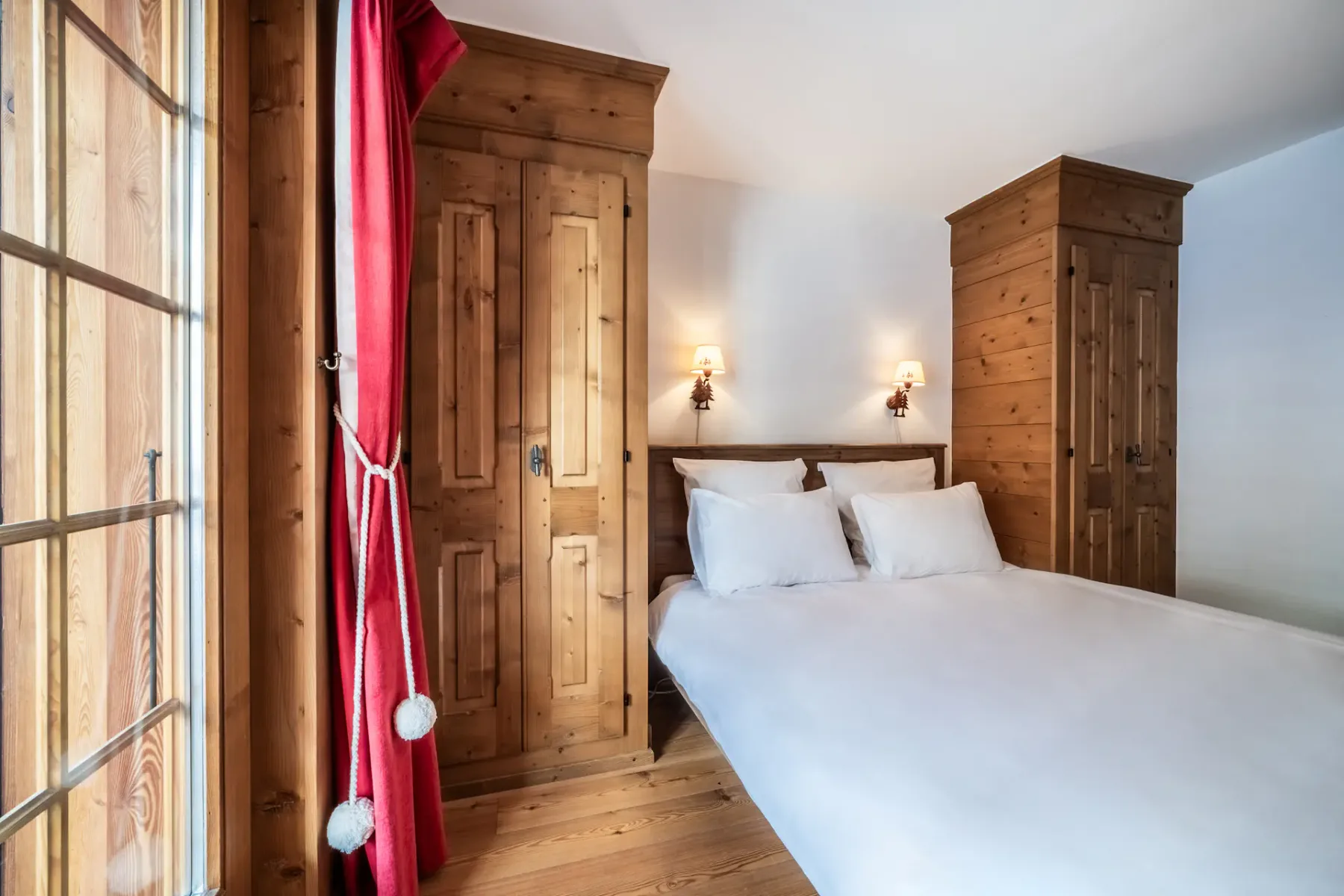 A wooden bedroom with a bed and a balcony.