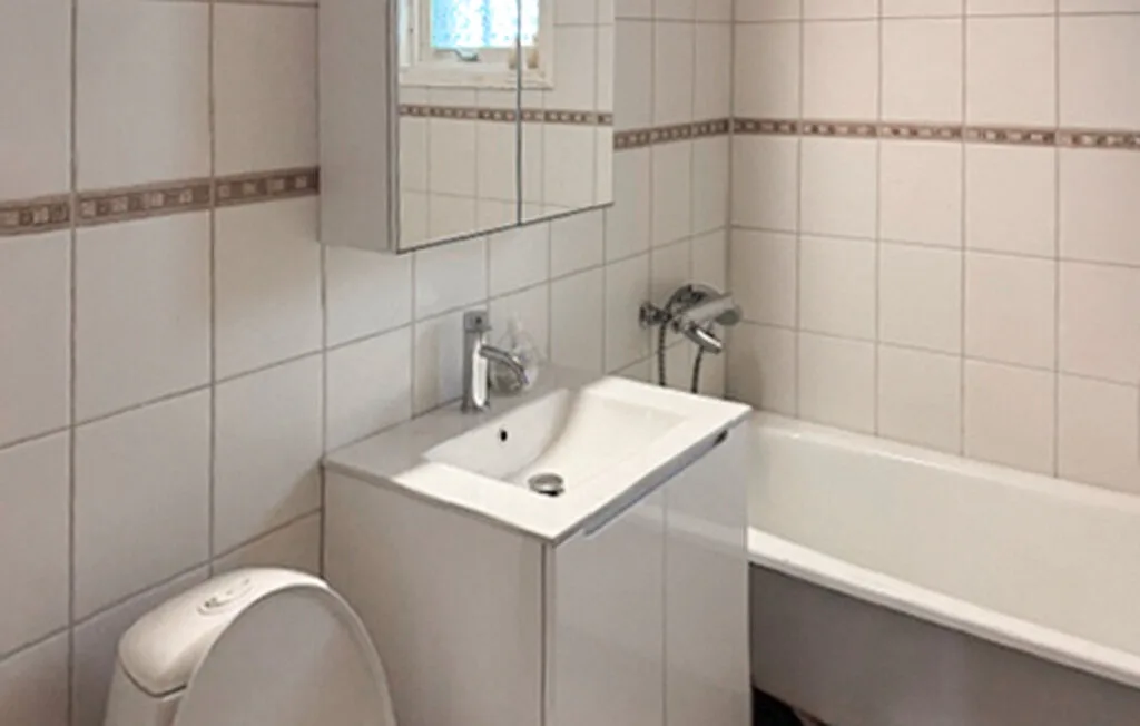 Un baño alicatado con lavabo, inodoro y bañera.