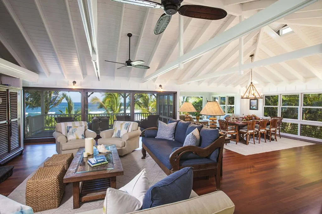 A bright open living and dining area with seating, a dining table, and large windows.
