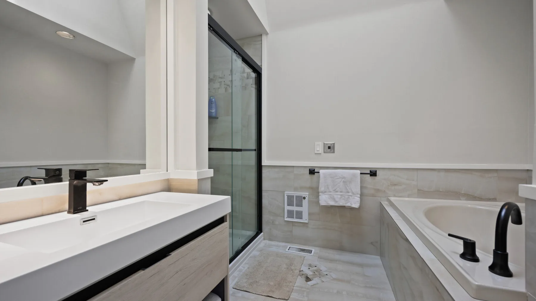 Un baño con ducha de vidrio y una bañera junto al lavabo.