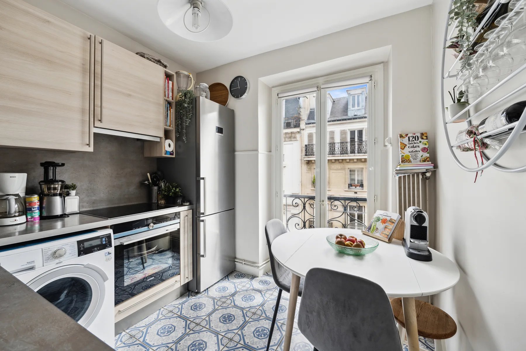 A compact kitchen and dining area with a table beside a large window.