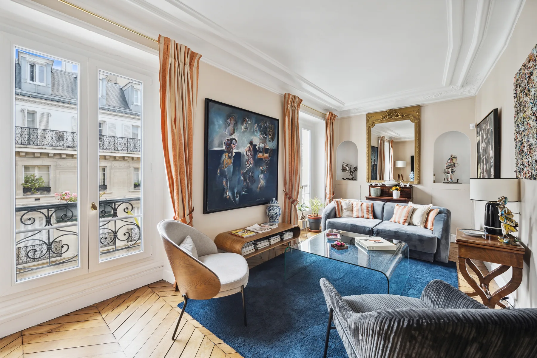 A bright living room with seating arranged around a glass coffee table.