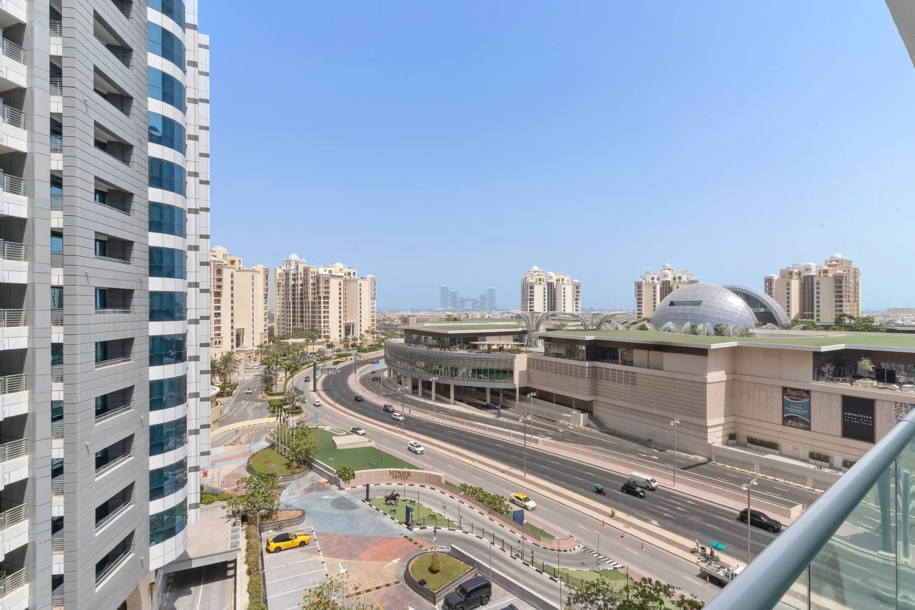 Paisaje urbano con carreteras curvas, edificios modernos y un cielo despejado.