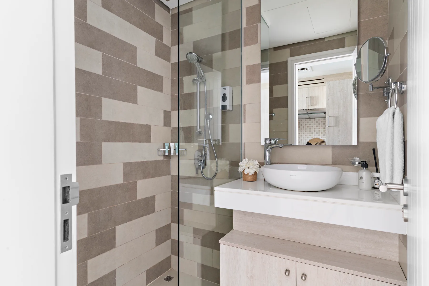 Un baño moderno con una ducha de vidrio y una amplia encimera con lavabo.