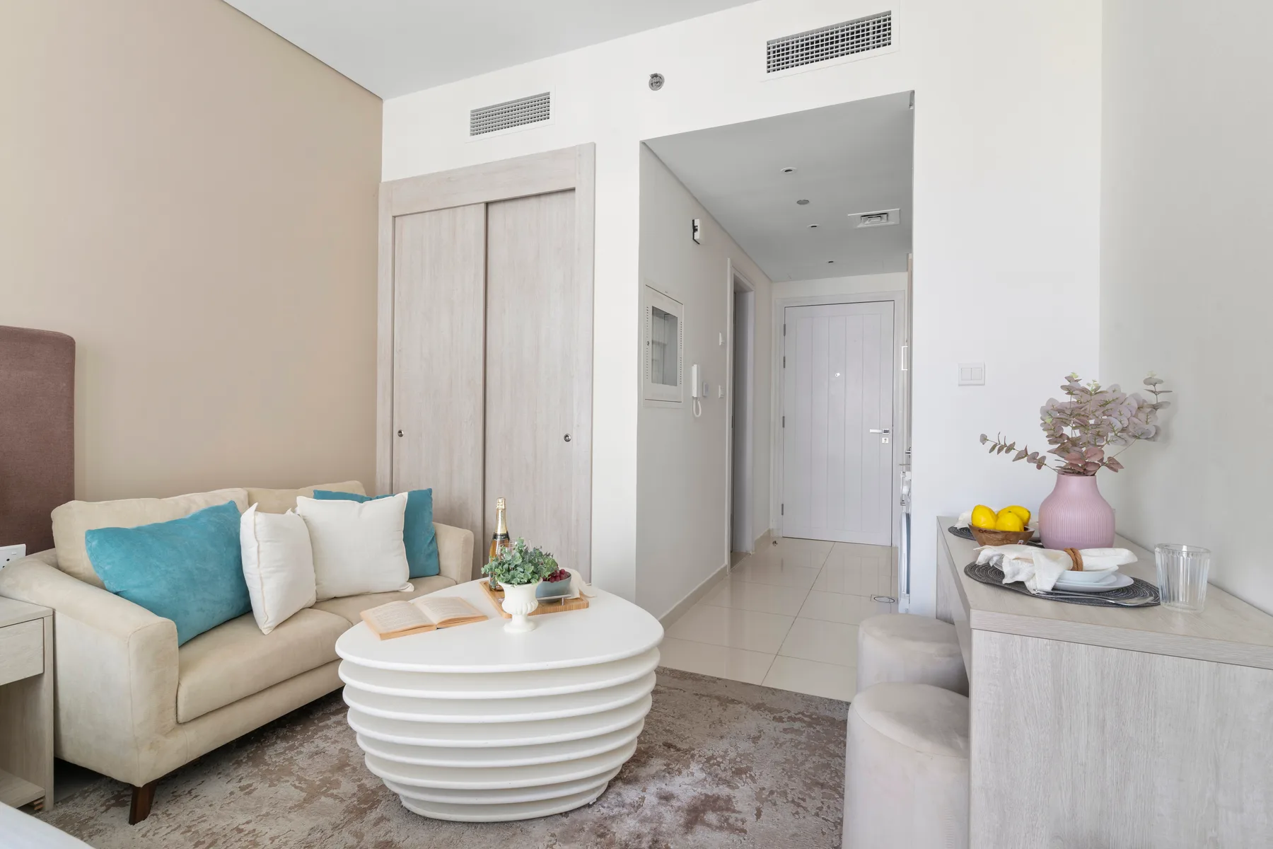 A bright living room with a sofa and round coffee table.