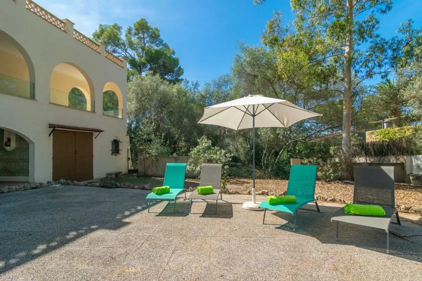 An outdoor patio with a white umbrella and turquoise seating.