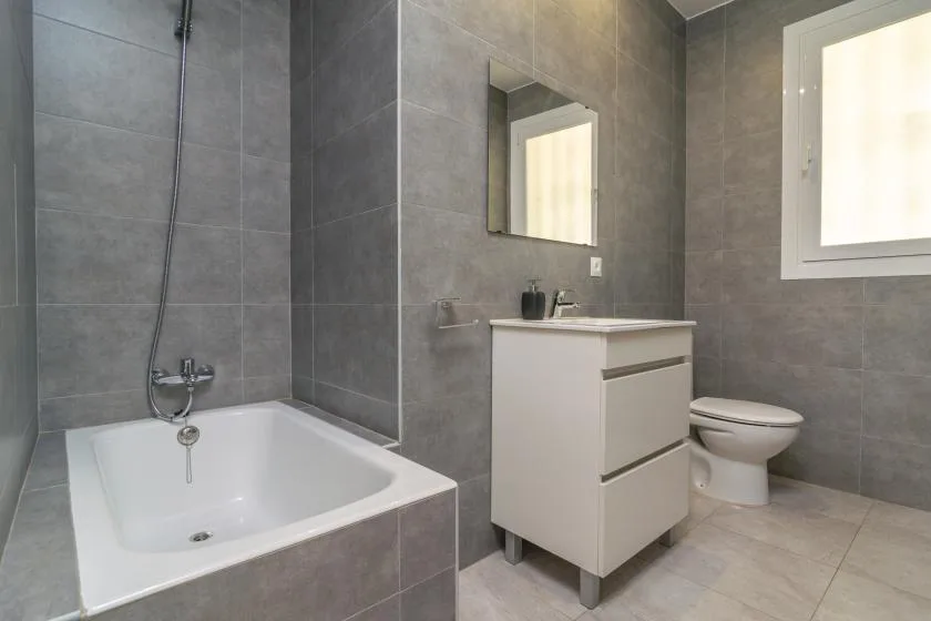 A bathroom with a bathtub, vanity, and toilet.