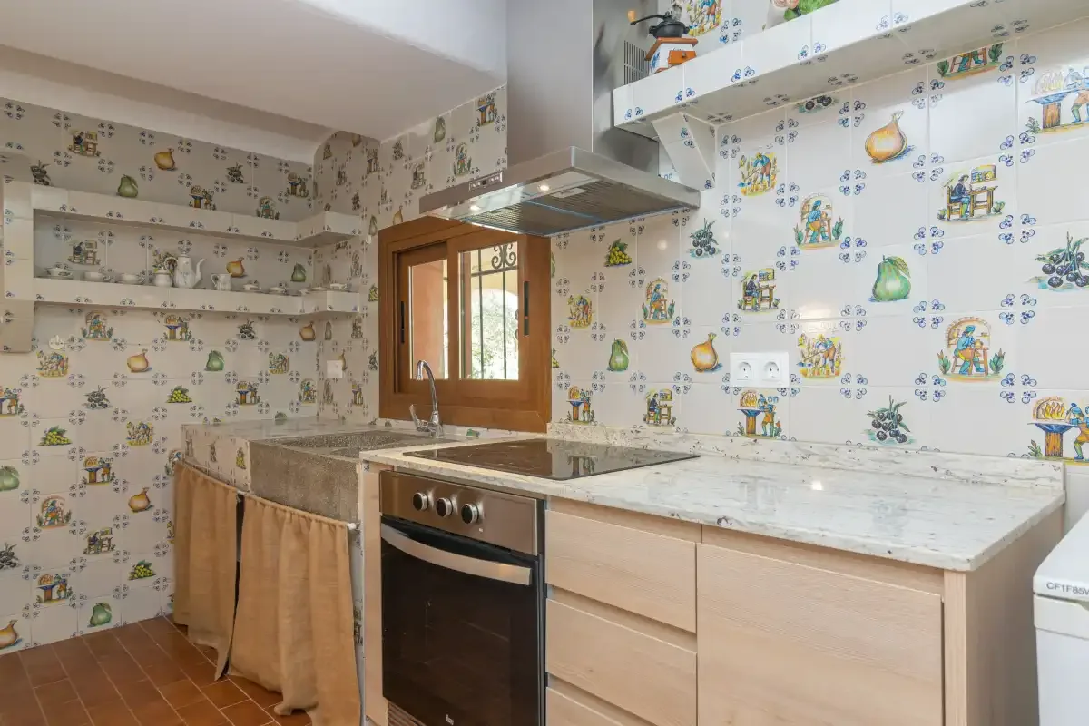 A kitchen with tiled counters and wooden cabinets.