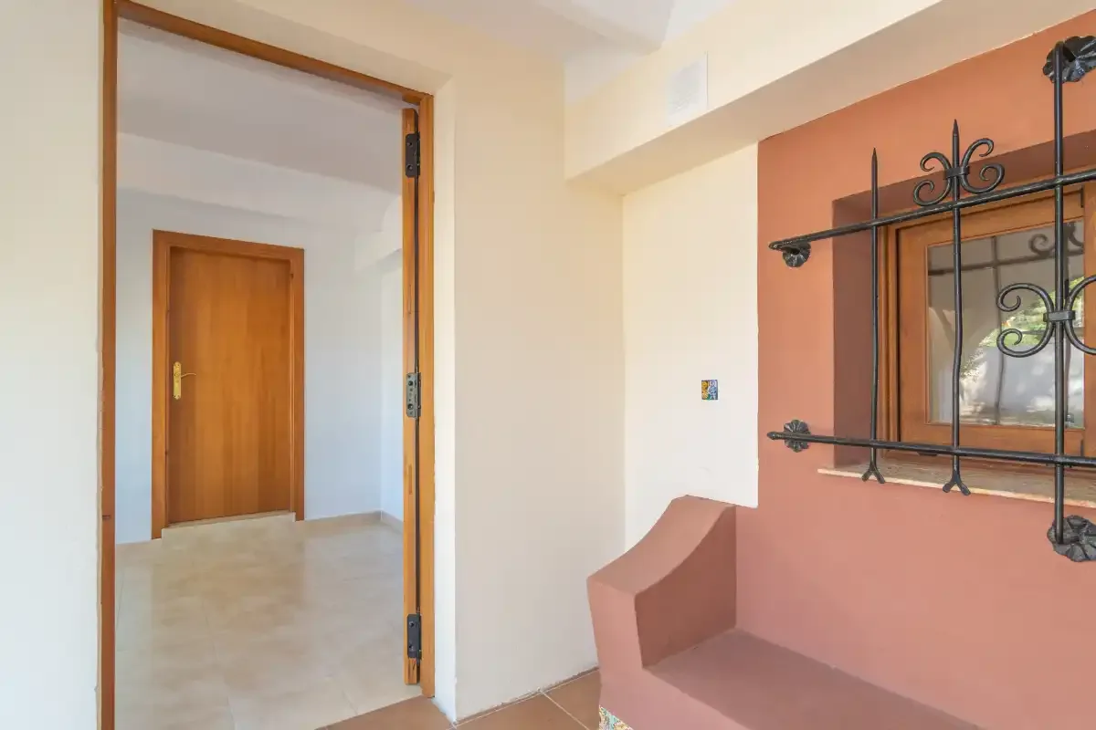 An interior hallway opens onto a small seating nook beside a window.