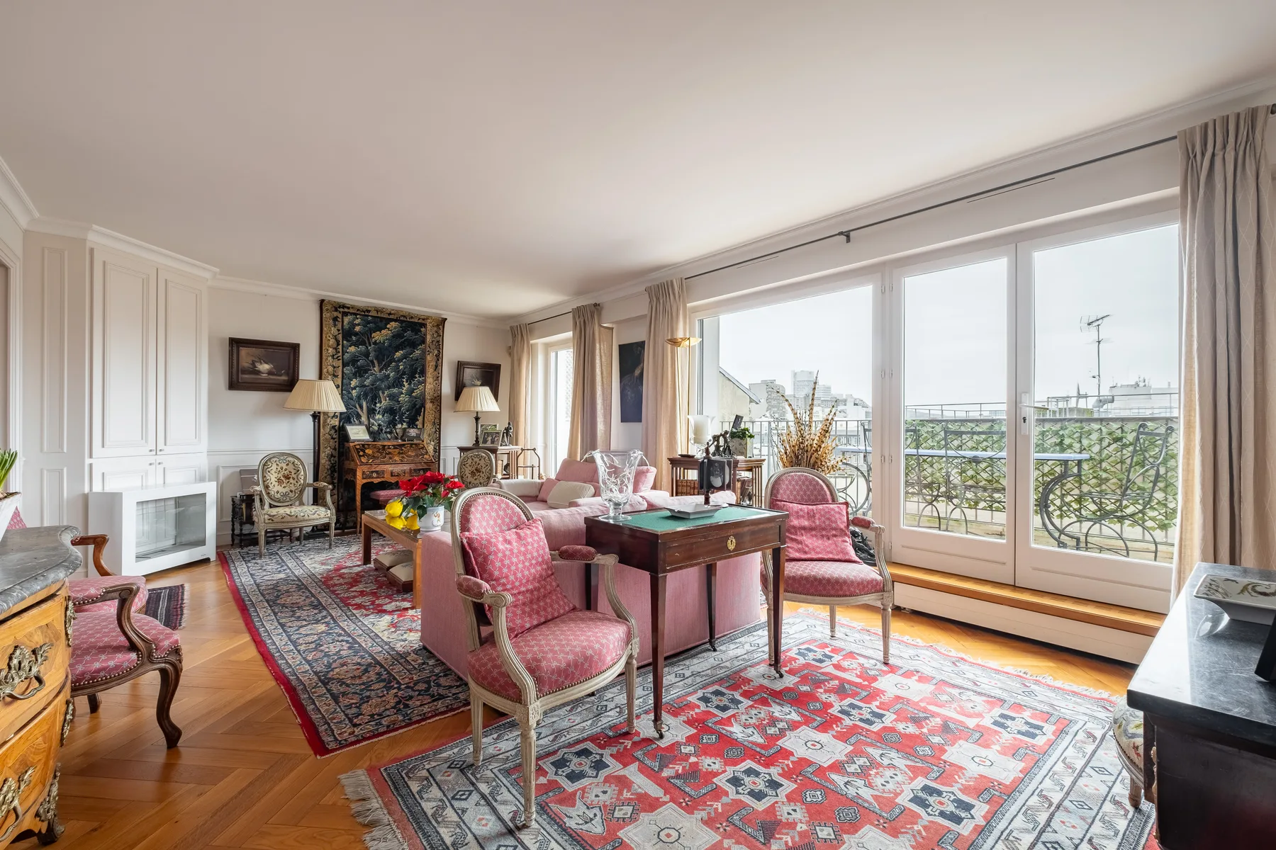 A bright living room with seating, a dining table, and large windows.