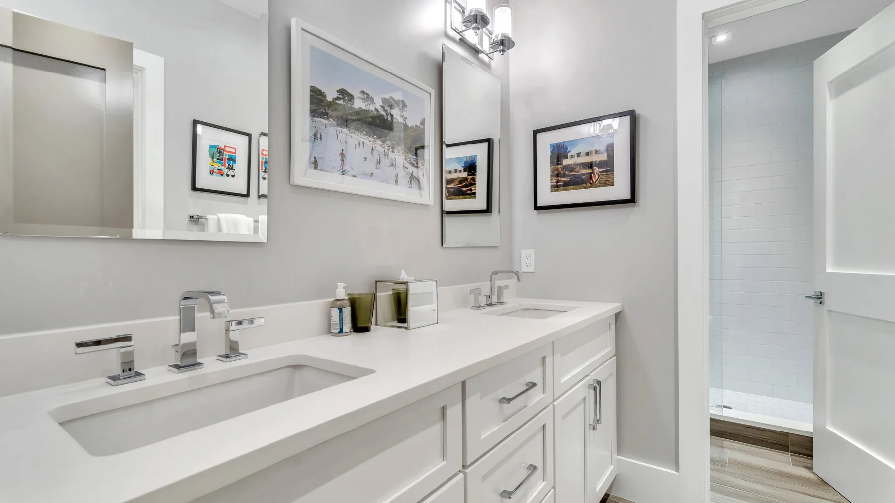 Un tocador de baño luminoso con lavabo y cuadros en la pared.