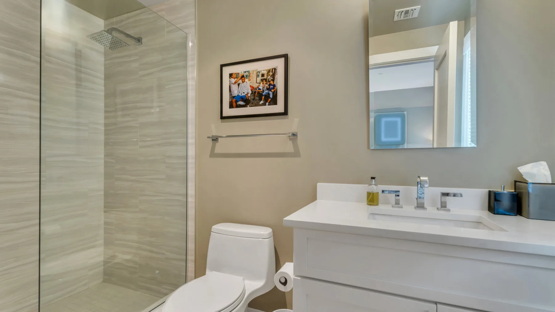 Un baño con ducha de vidrio, inodoro y lavabo.