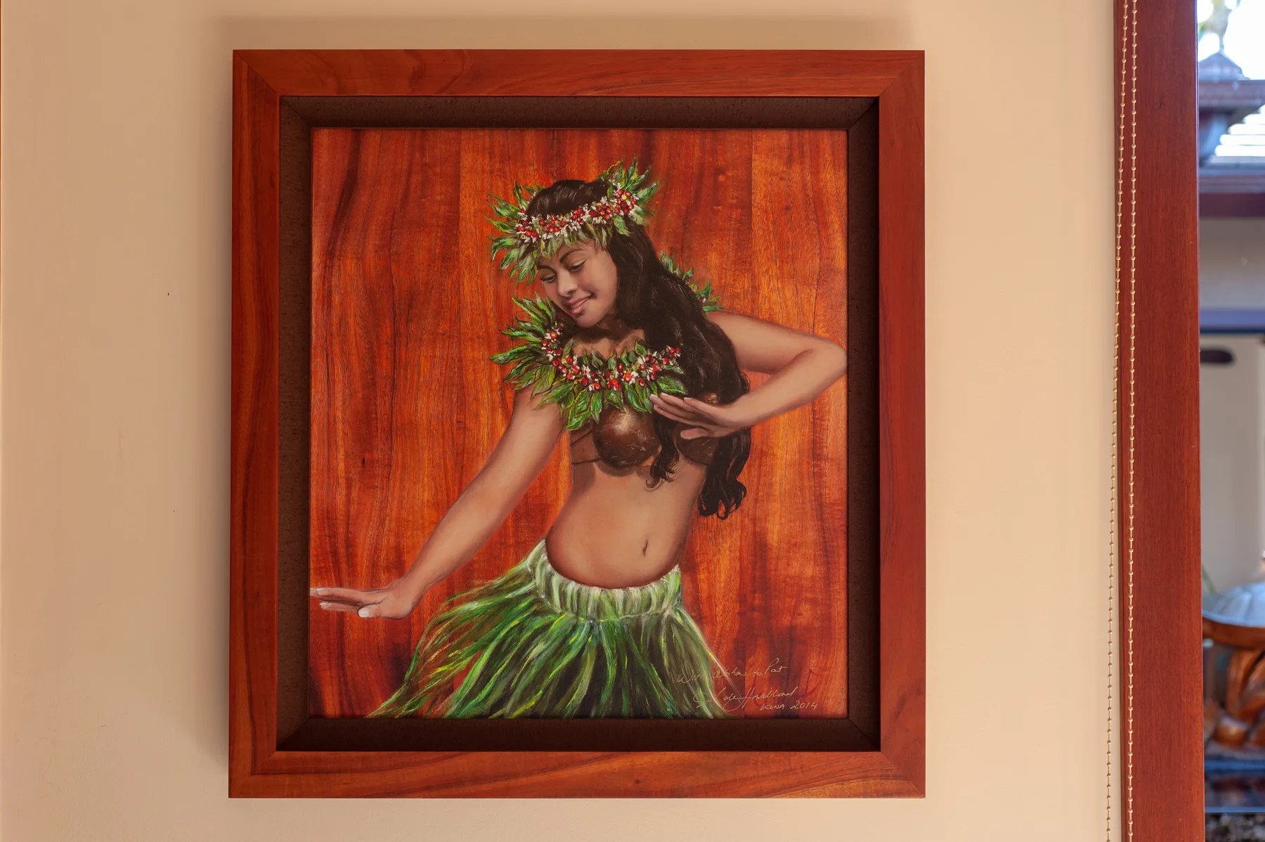 A framed artwork depicts a dancer wearing a leafy skirt and floral garland.
