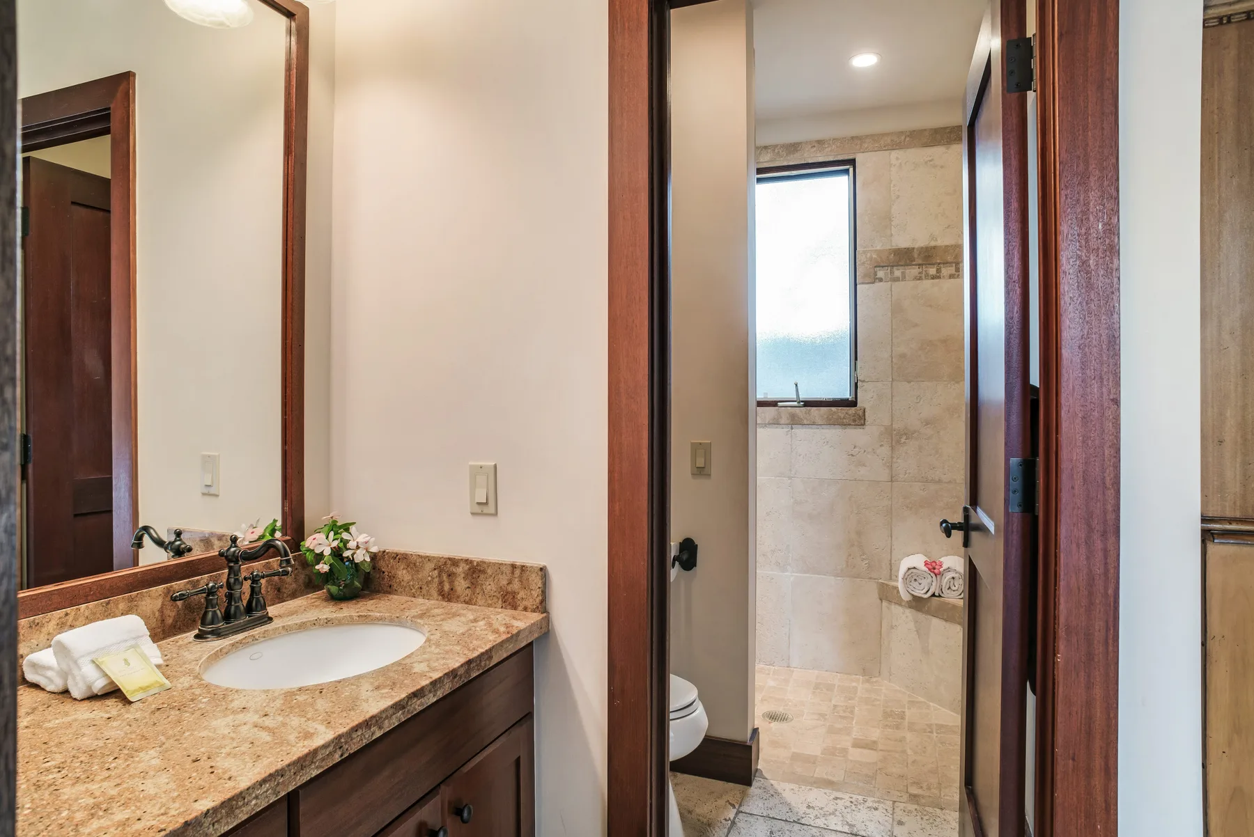 A bathroom vanity and sink beside a tiled shower area.