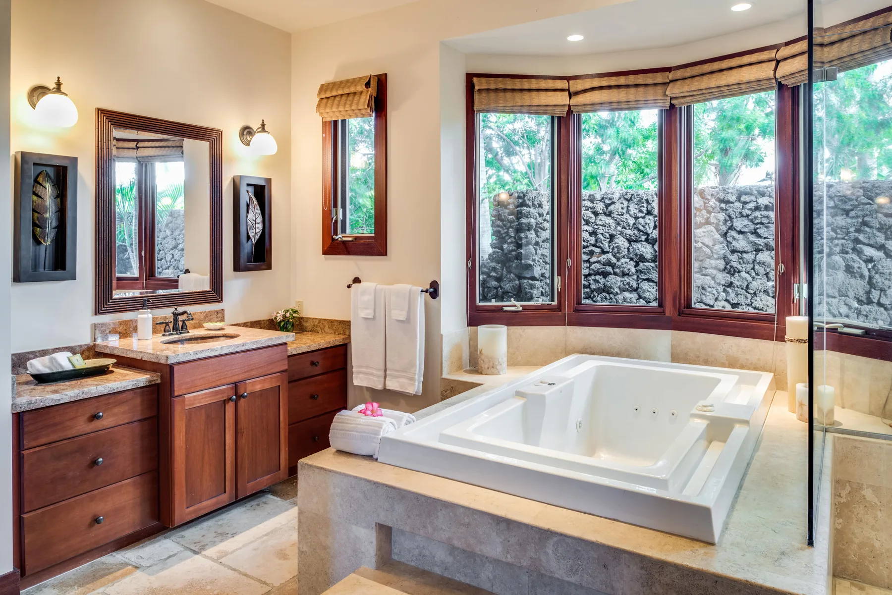 A bathroom with a large soaking tub, vanity, and wide windows.