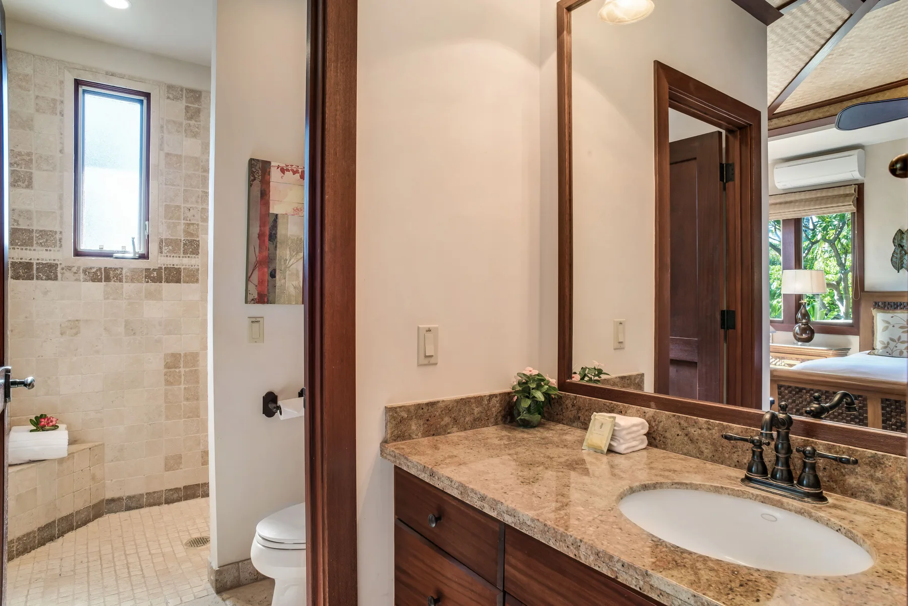 A bathroom vanity with a sink and mirror beside a tiled shower area.