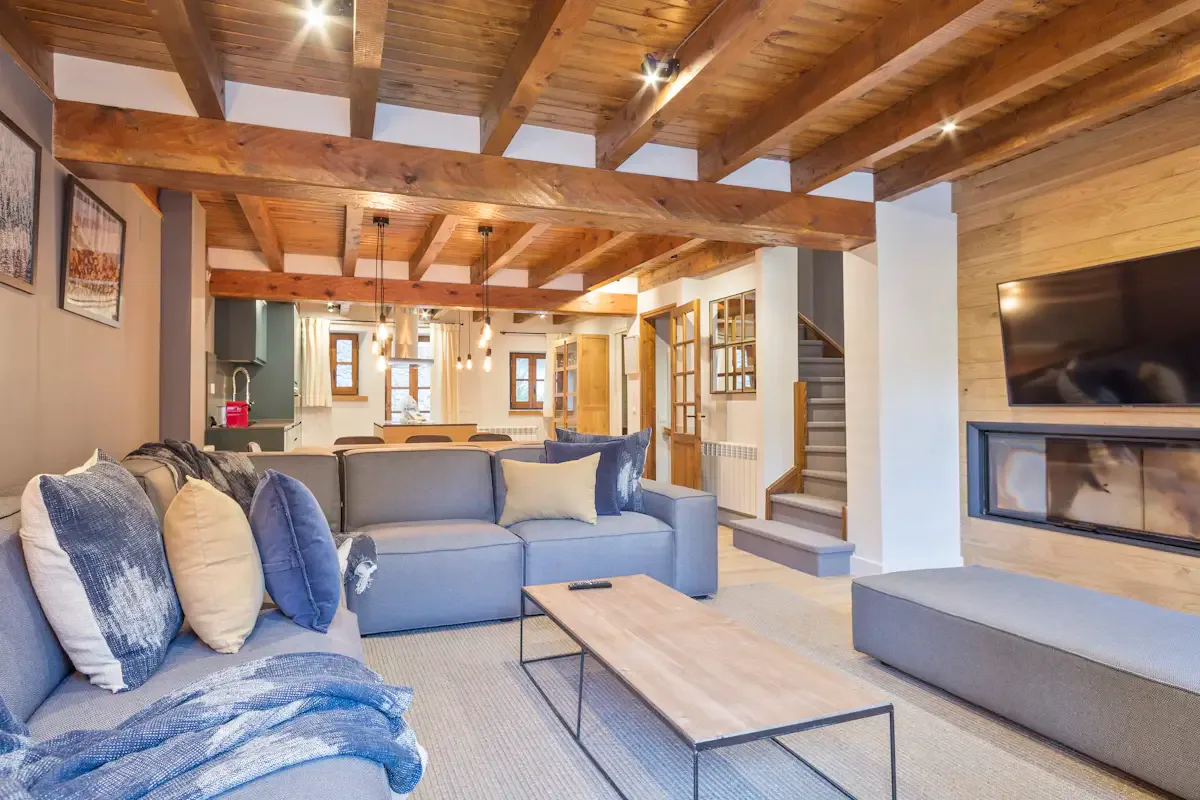 A living room with blue seating, a low coffee table, and a fireplace.
