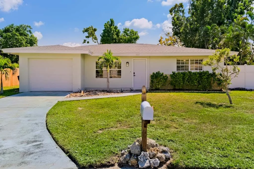 A single-story house with a driveway, front lawn, and mailbox.