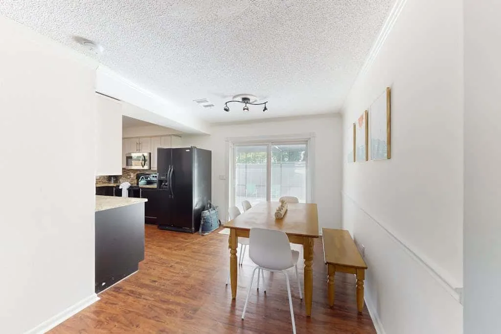 A dining area with a table and chairs sits beside a kitchen.