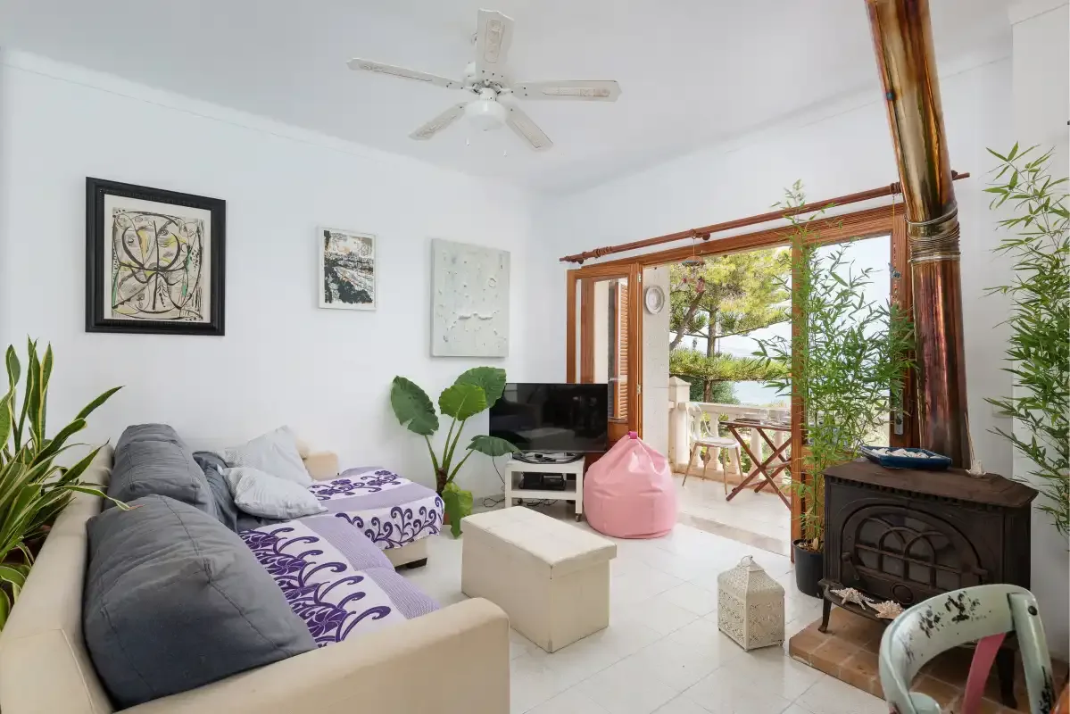 A bright living room with seating, a television, and sliding glass doors opening to a patio.