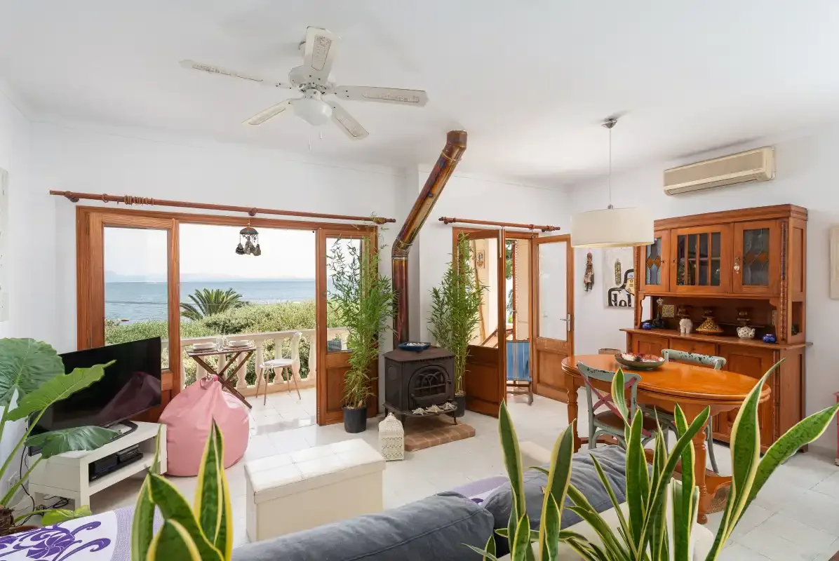 A bright living room opens onto a balcony with a sea view.