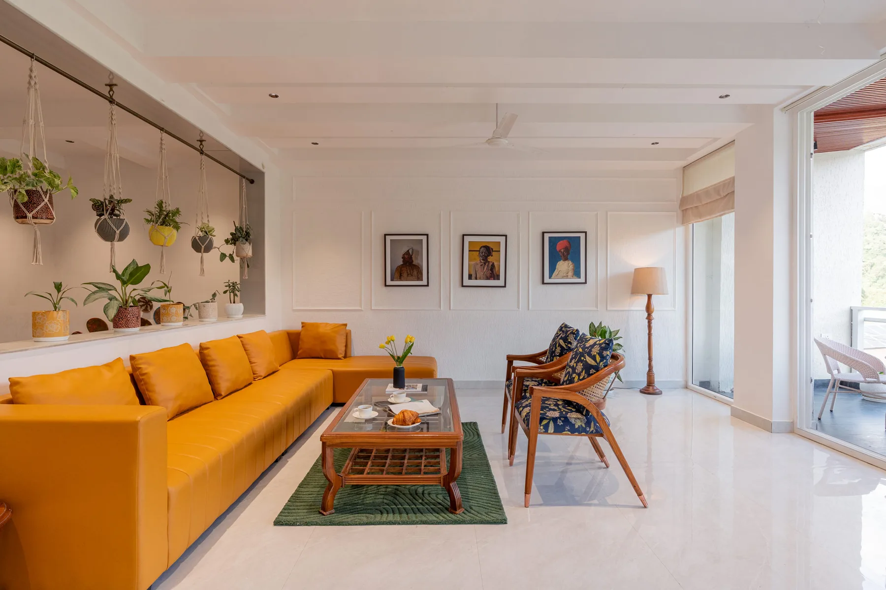 Una sala luminosa con asientos naranjas, una mesa de centro y cuadros enmarcados.