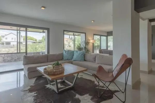Una sala luminosa tiene una zona de asientos junto a grandes ventanales.