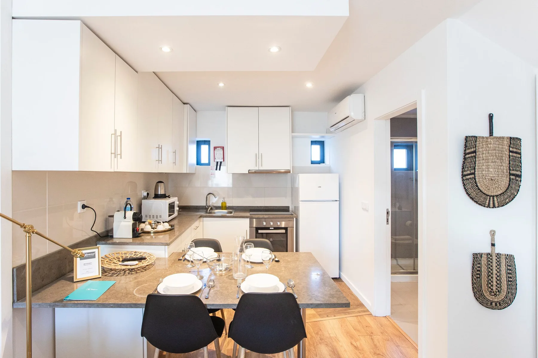 A bright kitchen and dining area with a counter and black seating.