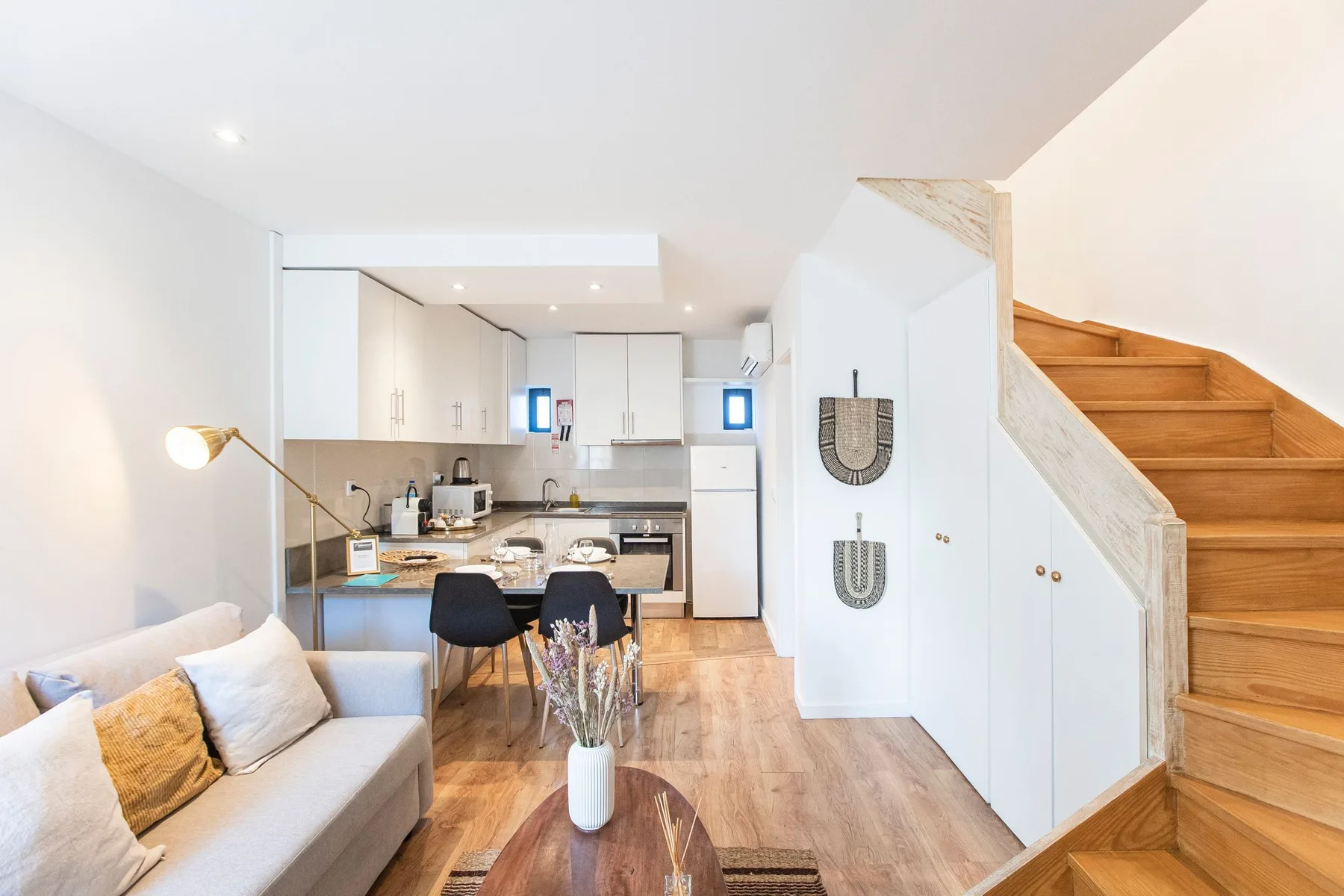 An open-plan living area with seating, a dining table, and a kitchen.