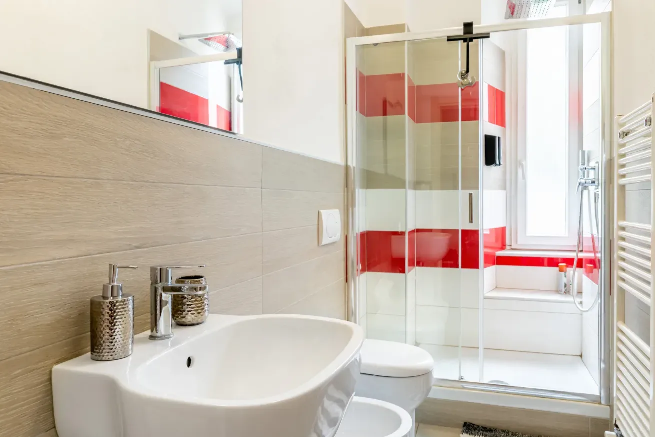 Un baño con lavabo, inodoro y ducha de vidrio.