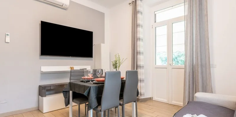 Un comedor con una mesa y sillas junto a una ventana grande.