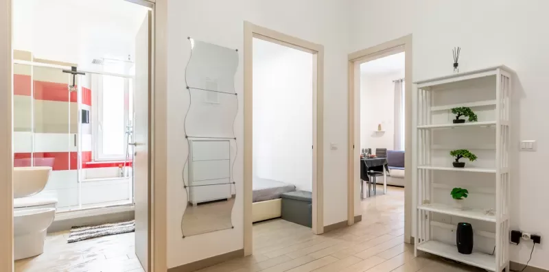 Un pasillo luminoso da a un baño y a habitaciones contiguas.