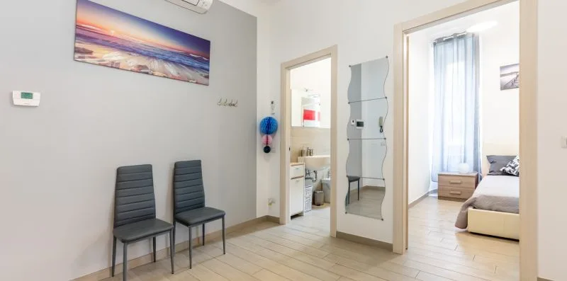 Un pasillo luminoso da a un baño y un dormitorio.