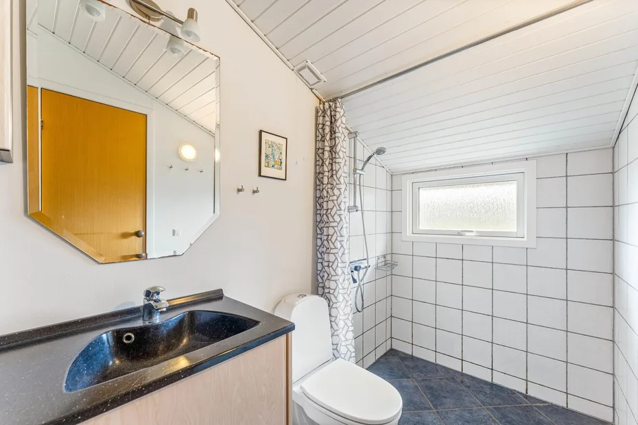 Un baño con azulejos, lavabo, inodoro y ducha.