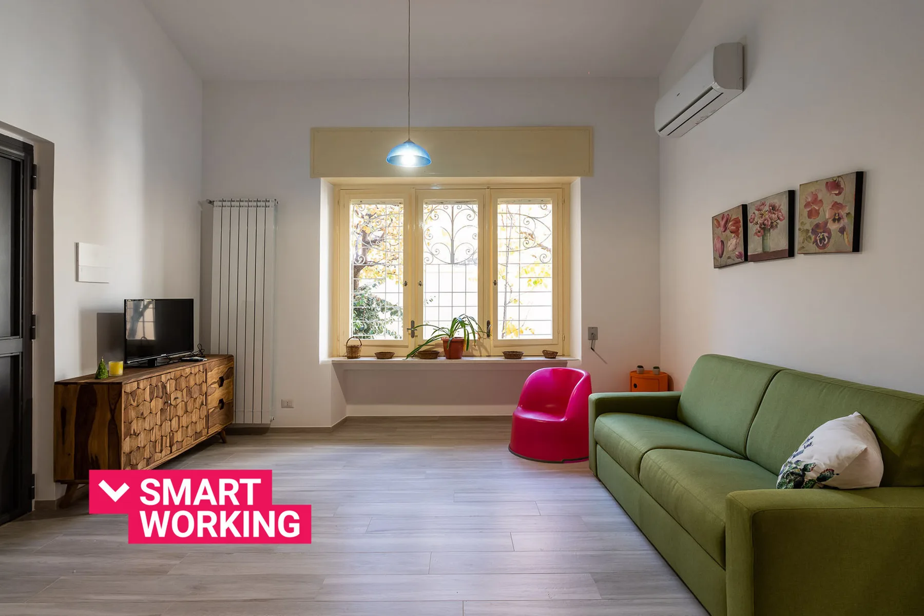 A bright living room with a green sofa and large windows.