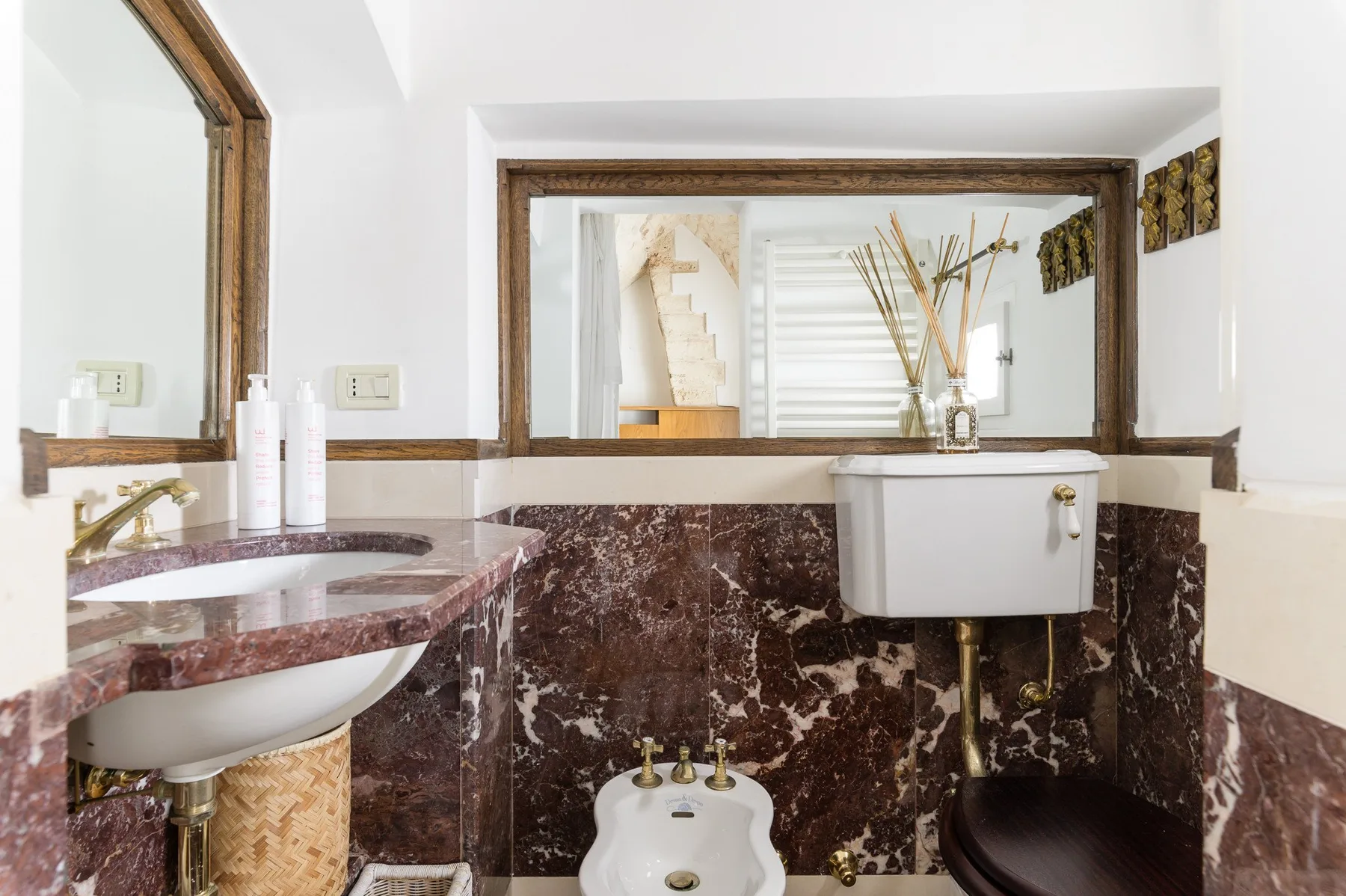 Un baño con lavabo, bidé y una pila montada en la pared.