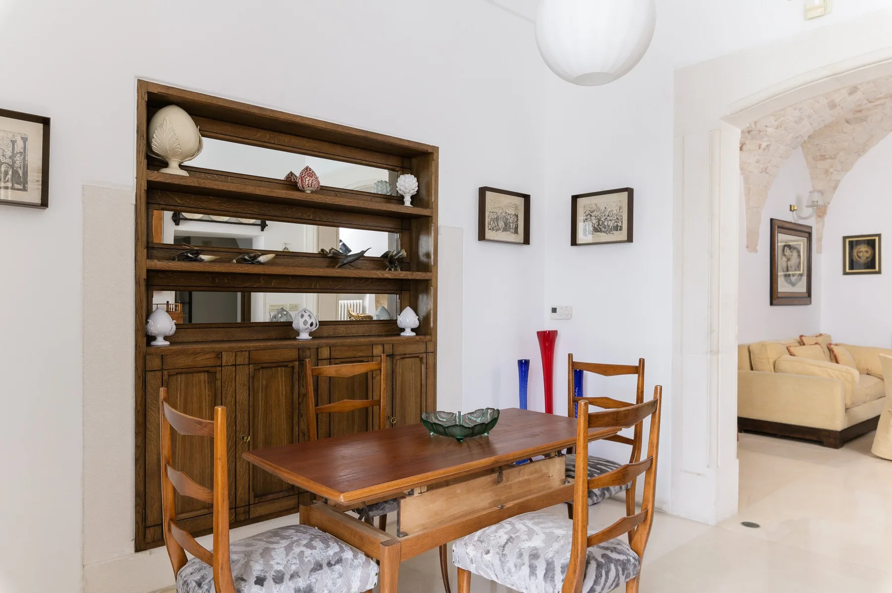 Un comedor con una mesa de madera y sillas frente a un mueble empotrado.