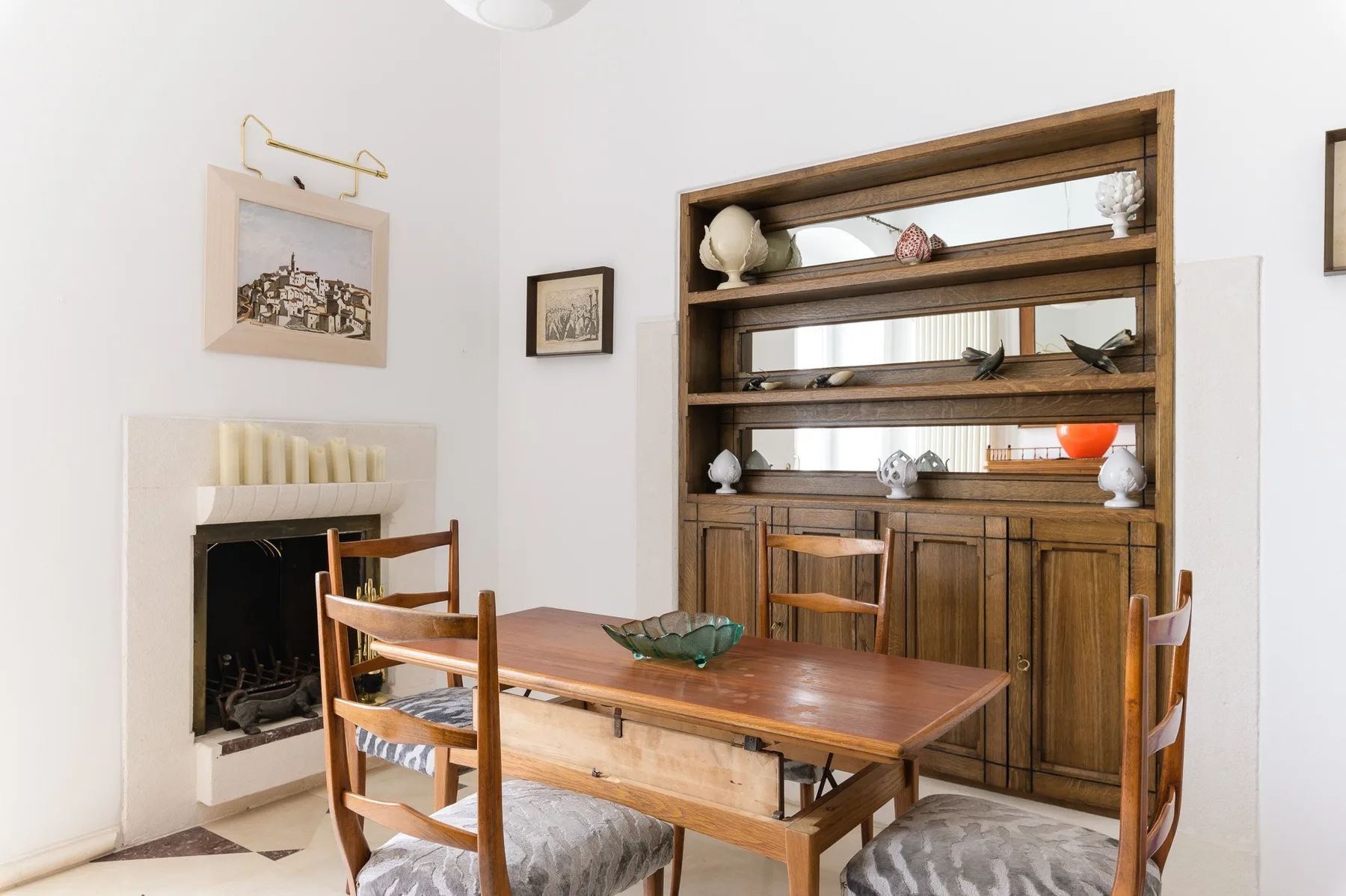 Comedor con una mesa de madera y estanterías empotradas.