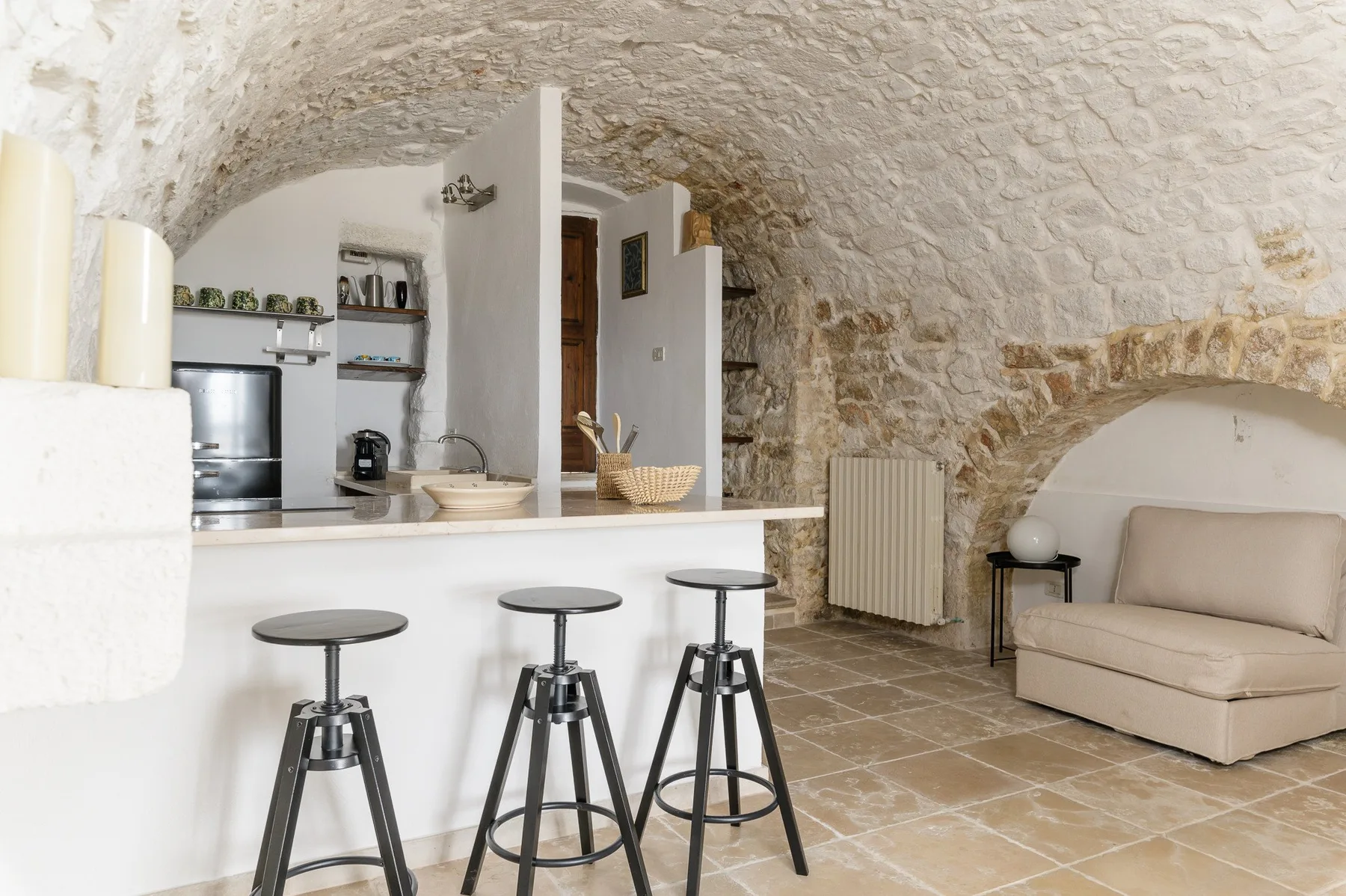 Una cocina y sala de estar con bóveda de piedra, barra y asientos.